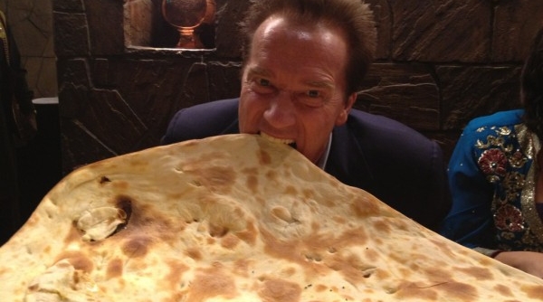 226043-arnold-schwarzenegger-with-naan-a-kind-of-indian-bread_600_334_c1